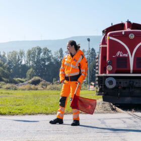 Sujet im Rahmen der Unternehmensfotografie, corporate photography DPB. Eine Mitarbeiterin sichert den Bahnübergang